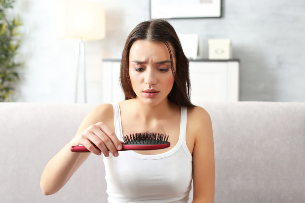 young woman with hair loss problem at home